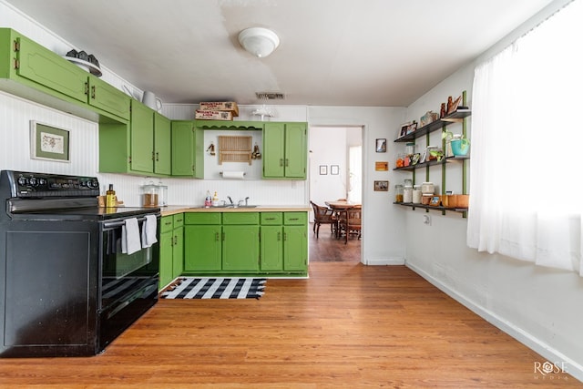 kitchen featuring black range with electric cooktop, light hardwood / wood-style floors, sink, and green cabinets