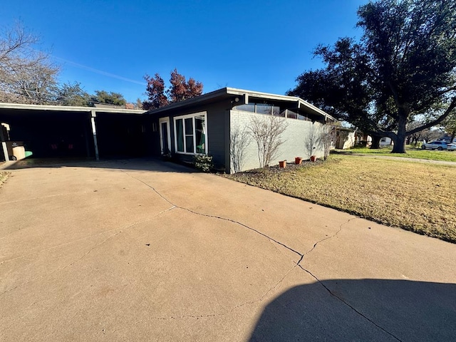 view of home's exterior featuring a yard and a carport