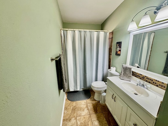 bathroom featuring tasteful backsplash, vanity, and toilet