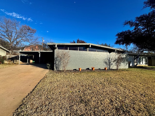 view of side of home with a carport and a lawn