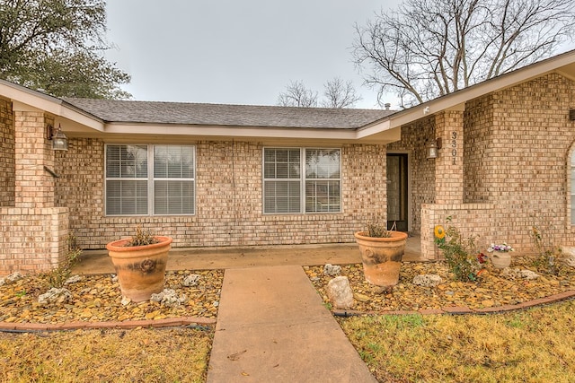 doorway to property featuring brick siding