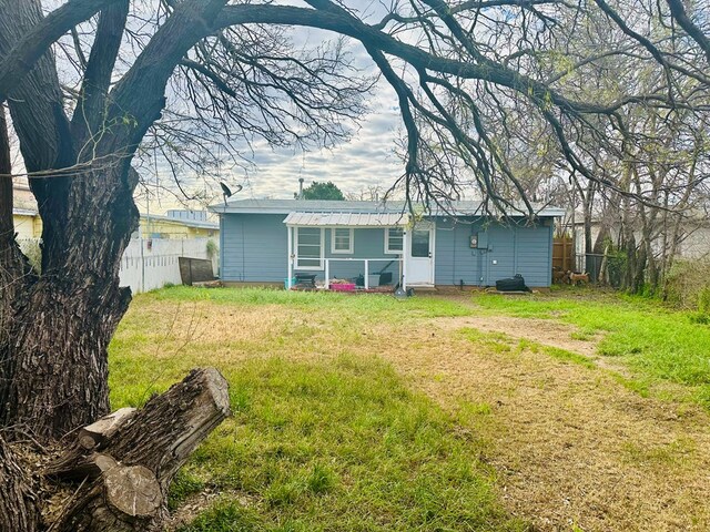 rear view of house featuring a lawn