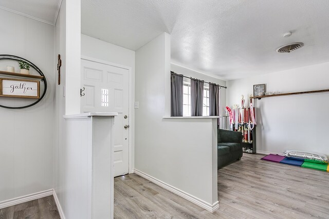 foyer featuring light hardwood / wood-style floors and a textured ceiling