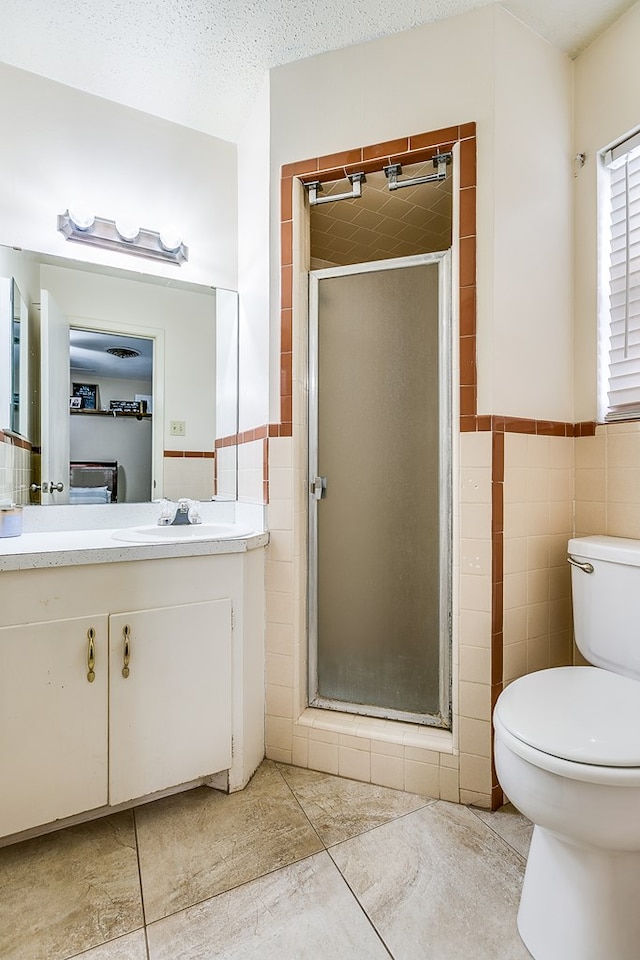 bathroom featuring tile walls, vanity, a textured ceiling, toilet, and walk in shower