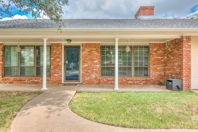 entrance to property with a lawn