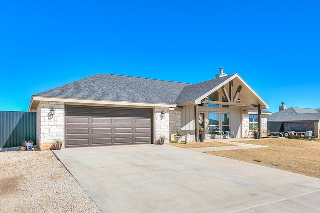 view of front of property with board and batten siding, concrete driveway, an attached garage, a shingled roof, and stone siding