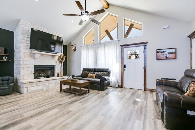 living area with ceiling fan, beam ceiling, a fireplace, high vaulted ceiling, and wood finished floors