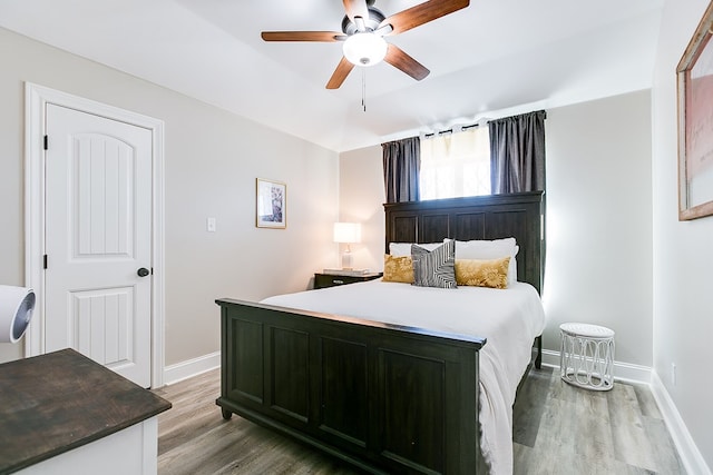 bedroom with baseboards, a ceiling fan, and wood finished floors