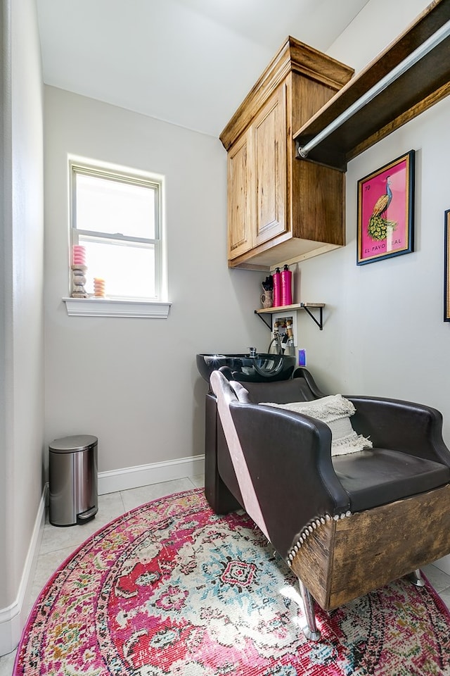 interior space with baseboards, hookup for a washing machine, cabinet space, and light tile patterned floors