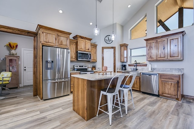 kitchen with a kitchen island, stainless steel appliances, high vaulted ceiling, and brown cabinets