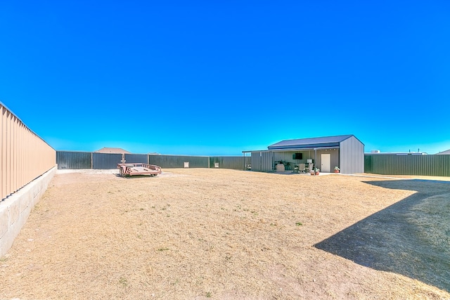 view of yard featuring a fenced backyard, an outdoor structure, and an outbuilding
