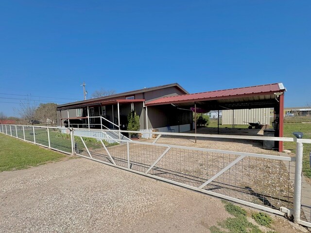 7754 S Copper Mountain Cir, San Angelo, TX 76901 - view of front of property with an exterior structure, a carport, an outdoor structure, and driveway