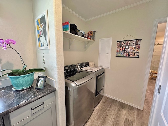 7754 S Copper Mountain Cir, San Angelo, TX 76901 - laundry room with washing machine and dryer, light wood-style flooring, ornamental molding, and electric panel