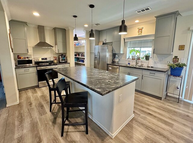 7754 S Copper Mountain Cir, San Angelo, TX 76901 - kitchen featuring wall chimney exhaust hood, appliances with stainless steel finishes, gray cabinets, light wood-style flooring, and recessed lighting
