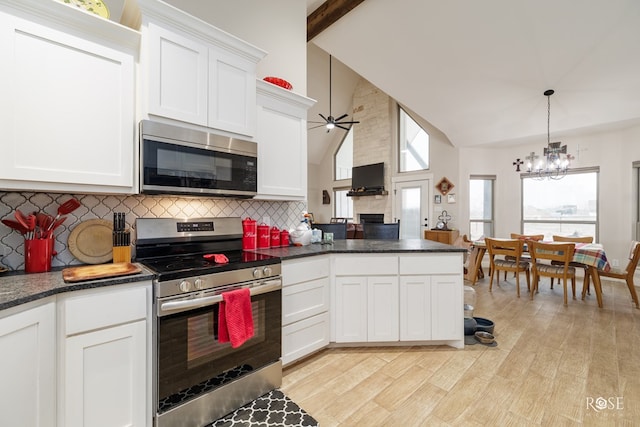 4400 Bobcat Trl, San Angelo, TX 76901 - kitchen featuring stainless steel appliances, backsplash, a chandelier, a fireplace, and high vaulted ceiling
