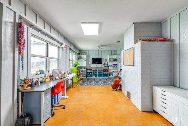 interior space featuring concrete floors, brick wall, and ceiling fan