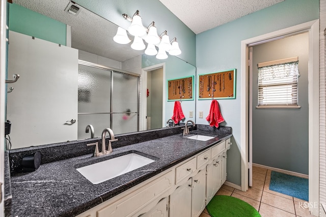 full bath with tile patterned flooring, visible vents, a sink, and a textured ceiling