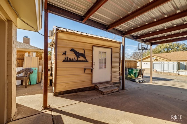 view of outbuilding featuring entry steps, an outdoor structure, and fence