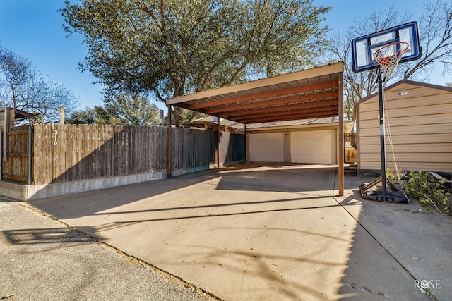 exterior space featuring driveway, fence, and an outdoor structure