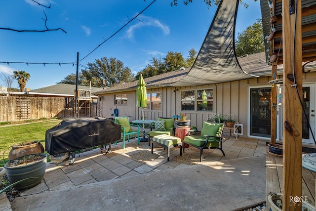 view of patio featuring fence and a grill