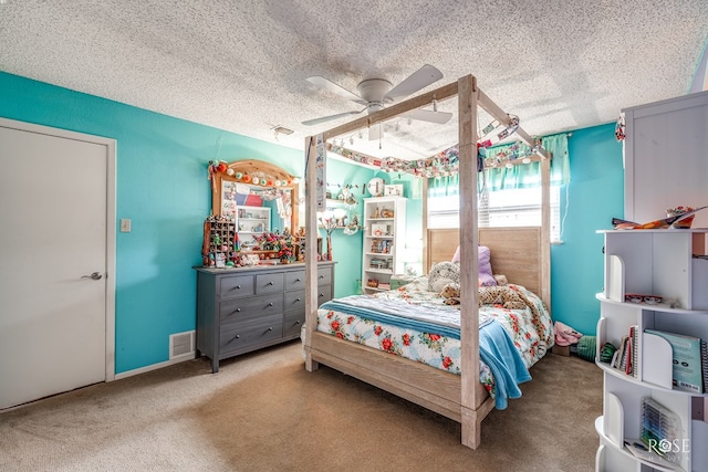 carpeted bedroom featuring a ceiling fan, visible vents, and a textured ceiling