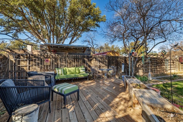 deck with an outdoor hangout area and a fenced backyard