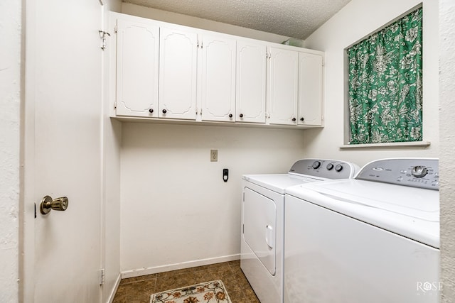 clothes washing area with cabinet space, independent washer and dryer, a textured ceiling, and baseboards