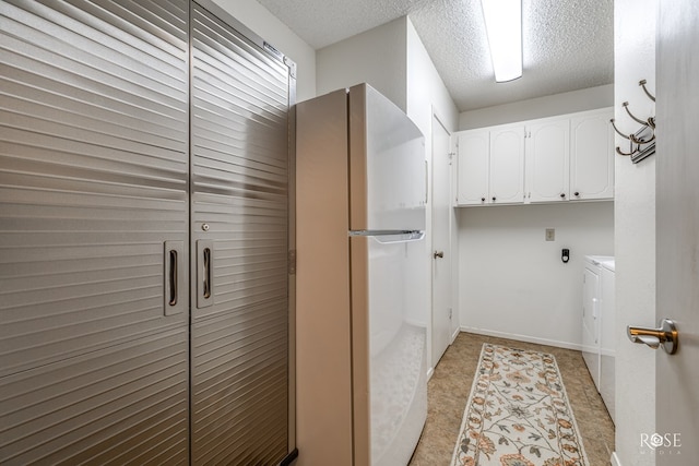 laundry room with cabinet space, a textured ceiling, and washing machine and clothes dryer