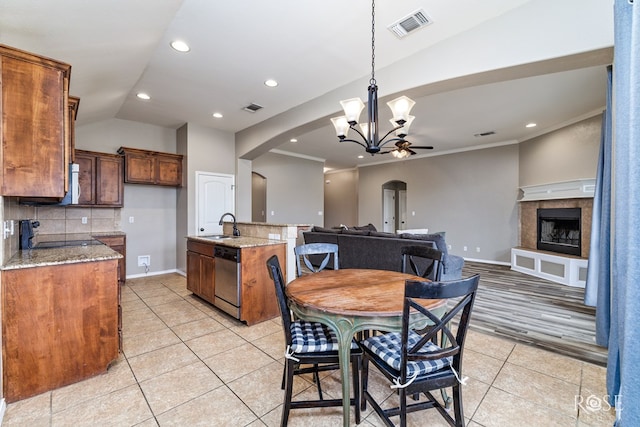 dining area with light tile patterned floors, visible vents, arched walkways, and ornamental molding