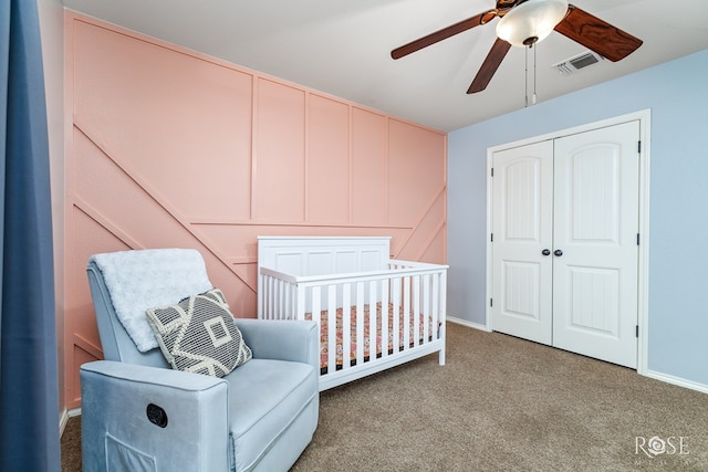 carpeted bedroom with visible vents, baseboards, ceiling fan, a nursery area, and a closet