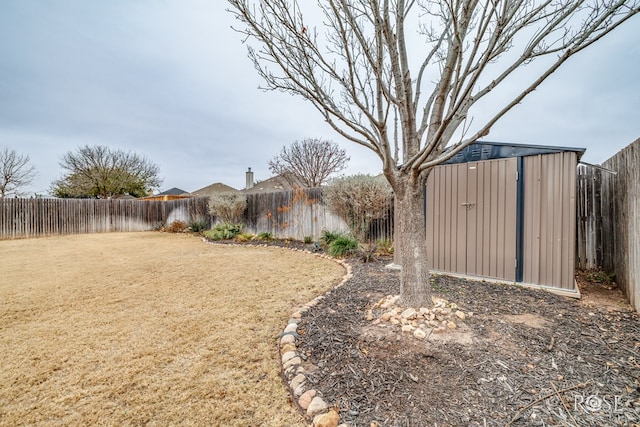 view of yard featuring a shed, an outdoor structure, and a fenced backyard