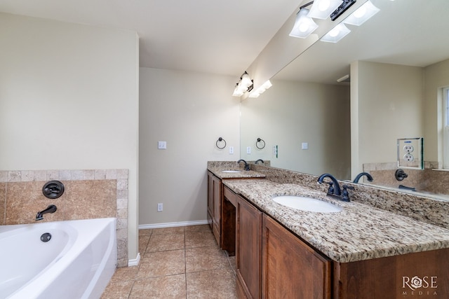 bathroom with double vanity, baseboards, a garden tub, tile patterned flooring, and a sink