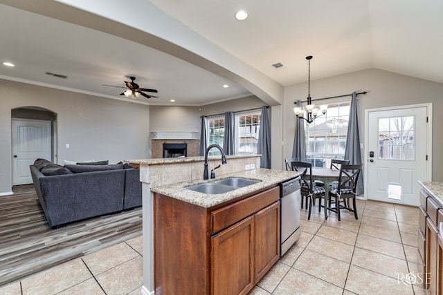 kitchen featuring arched walkways, a sink, visible vents, hanging light fixtures, and dishwasher