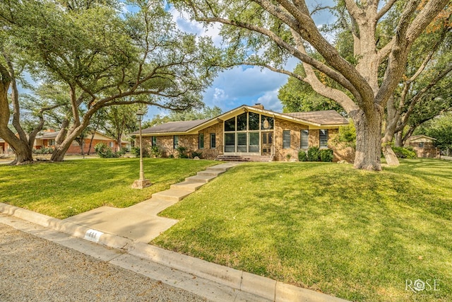 111 Manor St, Sonora, TX 76950 - mid-century inspired home with brick siding, a front yard, and a chimney