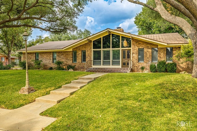 111 Manor St, Sonora, TX 76950 - mid-century inspired home with a chimney, a front yard, brick siding, and a metal roof