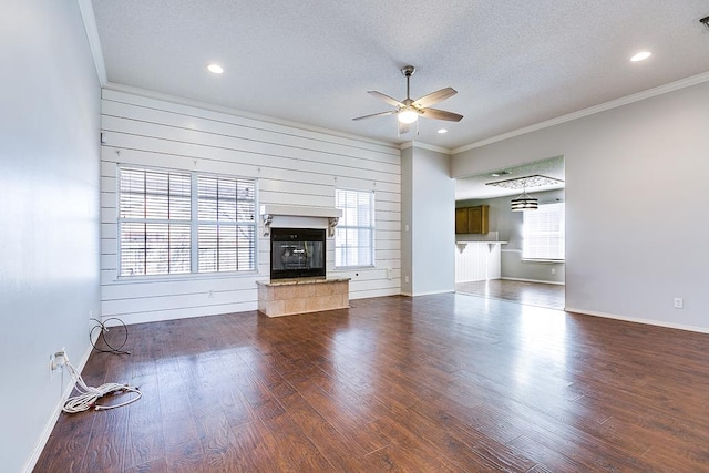 3622 Dominion Rdg, San Angelo, TX 76904 - unfurnished living room featuring a ceiling fan, ornamental molding, dark wood-type flooring, a textured ceiling, and a fireplace
