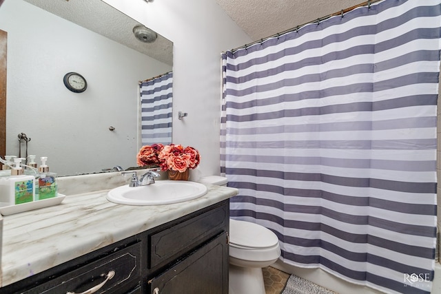 bathroom featuring vanity, toilet, and a textured ceiling