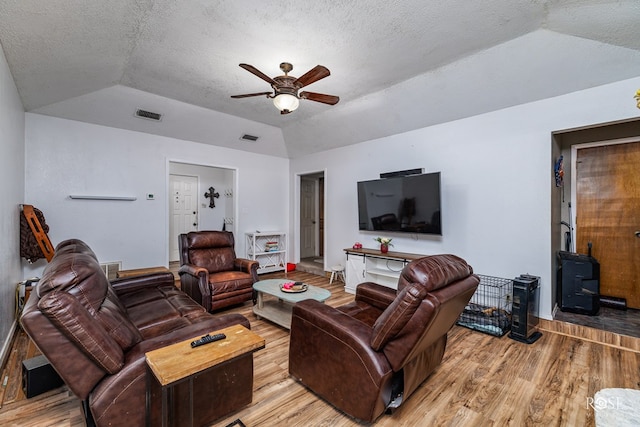 living room with lofted ceiling, hardwood / wood-style floors, a textured ceiling, and ceiling fan