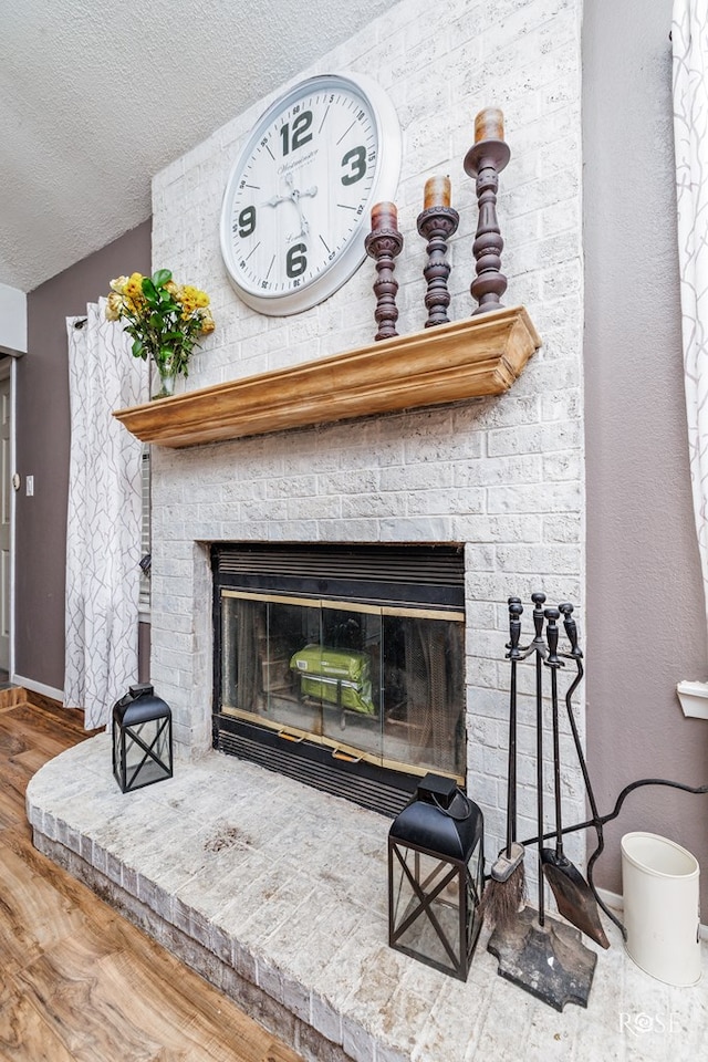 room details with wood-type flooring, a fireplace, and a textured ceiling