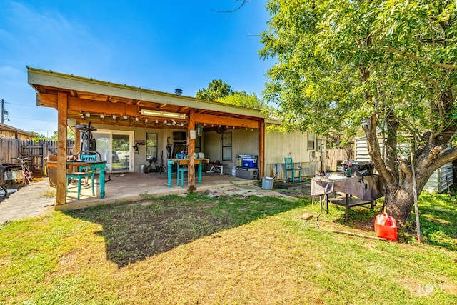 back of house featuring a lawn and a patio area