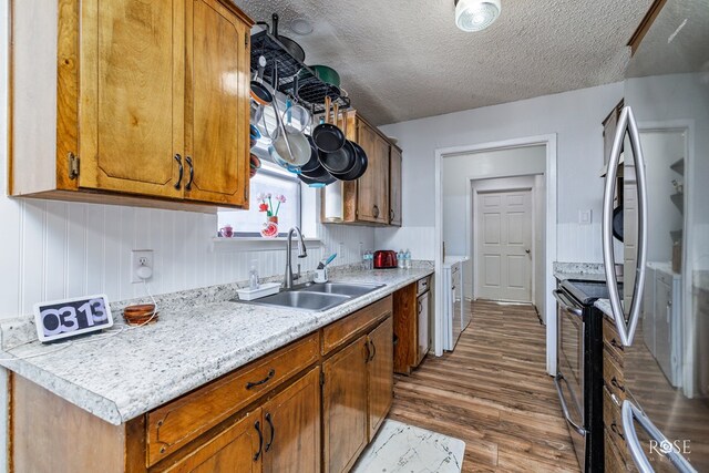 kitchen featuring stainless steel appliances, dark hardwood / wood-style flooring, sink, and a textured ceiling