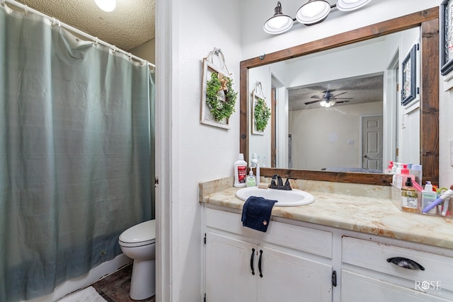 bathroom featuring ceiling fan, vanity, toilet, and a textured ceiling