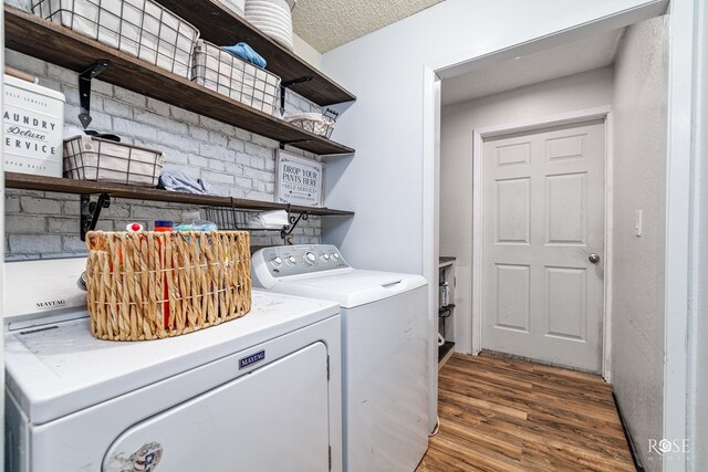 laundry area featuring hardwood / wood-style flooring, a textured ceiling, and washer and clothes dryer