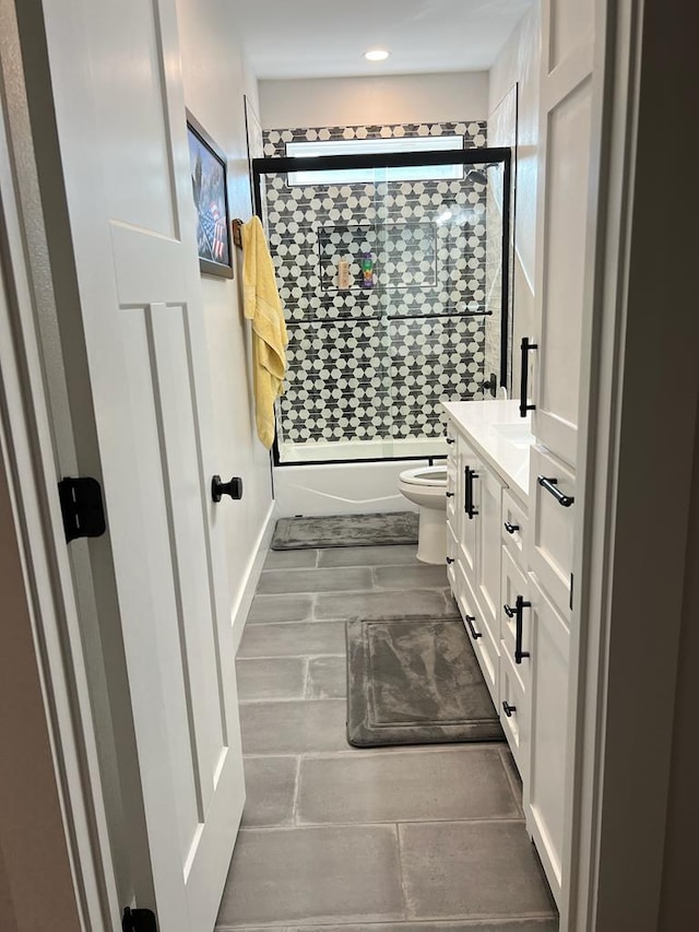 bathroom featuring recessed lighting, tiled shower, vanity, and toilet