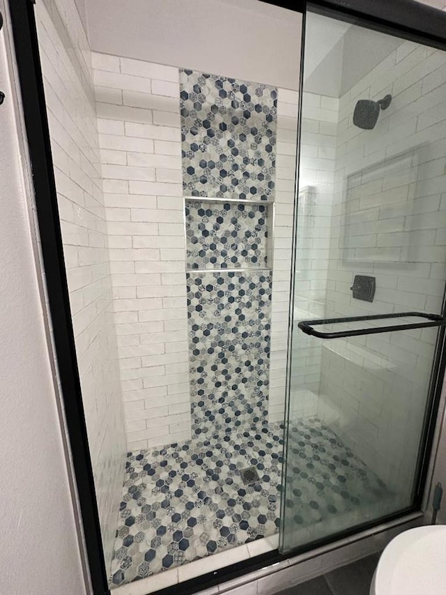 full bath featuring a shower stall and toilet