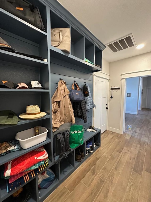 mudroom featuring wood finished floors, visible vents, and baseboards