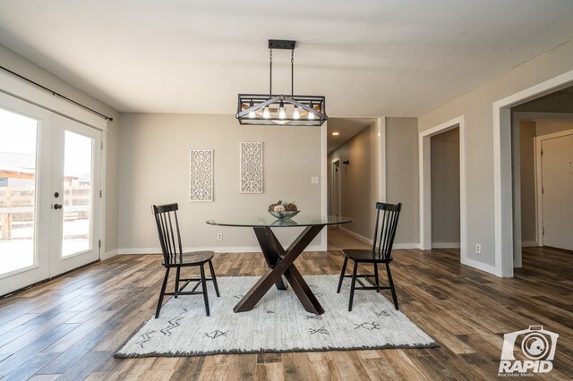 dining room with french doors, baseboards, an inviting chandelier, and wood finished floors