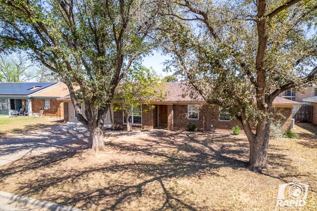 ranch-style house with brick siding, fence, and driveway