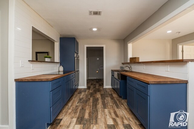 kitchen with visible vents, butcher block countertops, and blue cabinets