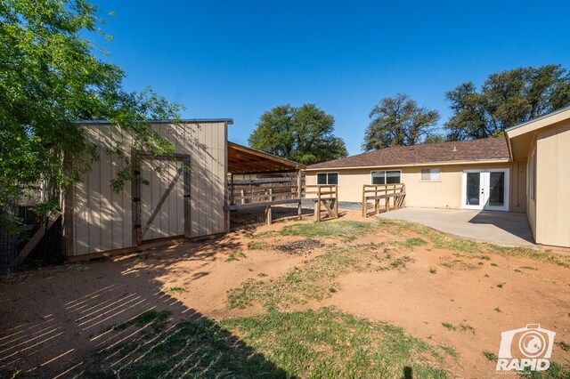 view of yard with french doors, a patio area, an exterior structure, and an outdoor structure
